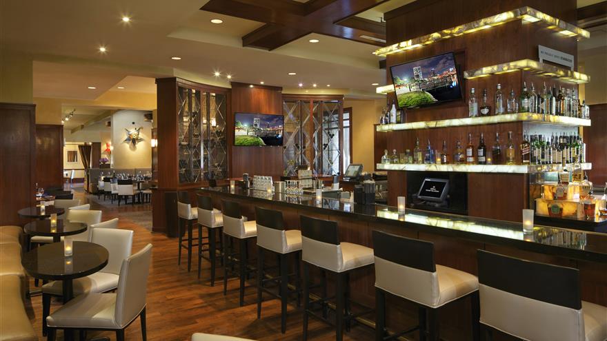 Full service bar featuring table, booth and bar seating at  Las Palmeras, a Hilton Grand Vacations Club in Orlando, Florida.