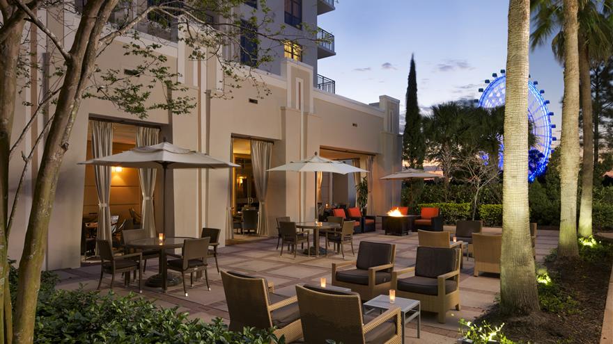 Cozy outdoor patio with a view of the I-Drive ferris wheel and palm trees at  Las Palmeras, a Hilton Grand Vacations Club in Orlando, Florida.