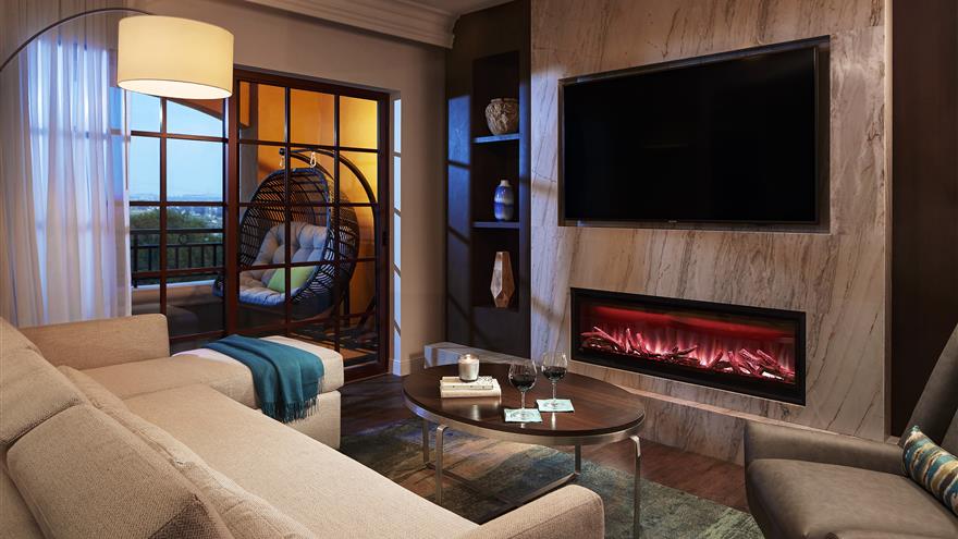 Living room with fireplace and TV at Hilton Grand Vacations at MarBrisa located in Carlsbad, California.