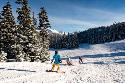 Idyllic alpine scene, group of people, skiing, snowboarding, snow-covered mountain. 