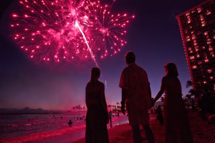 Group of people watching fireworks over Waikiki Beach, Hilton Hawaiian Village®, Honolulu, Hawaii. 