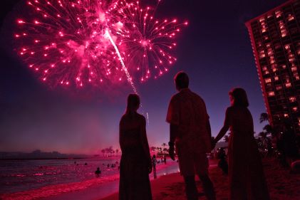 Group of people watching fireworks over Waikiki Beach, Hilton Hawaiian Village®, Honolulu, Hawaii. 