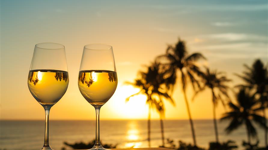 Two glasses of wine with the Hawaiian sunset in the background. 