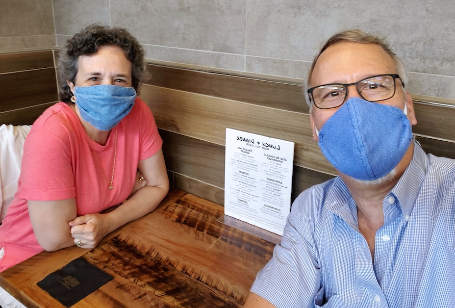 A mature couple wear face masks at the air-port on their way to vacation at Sunrise Lodge a Hilton Grand Vacations Club in Park City, Utah.