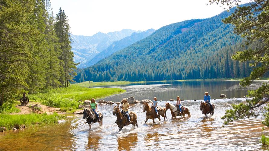 A group of people enjoying horseback riding on an guided adventure travel trip with Hilton Grand Vacations. 