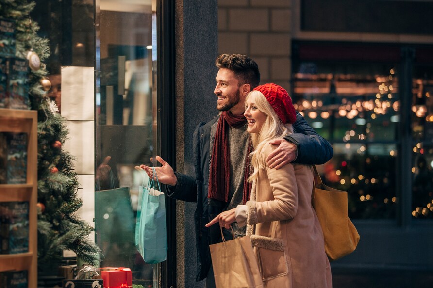 Happy couple window watching during Christmas in New York City.
