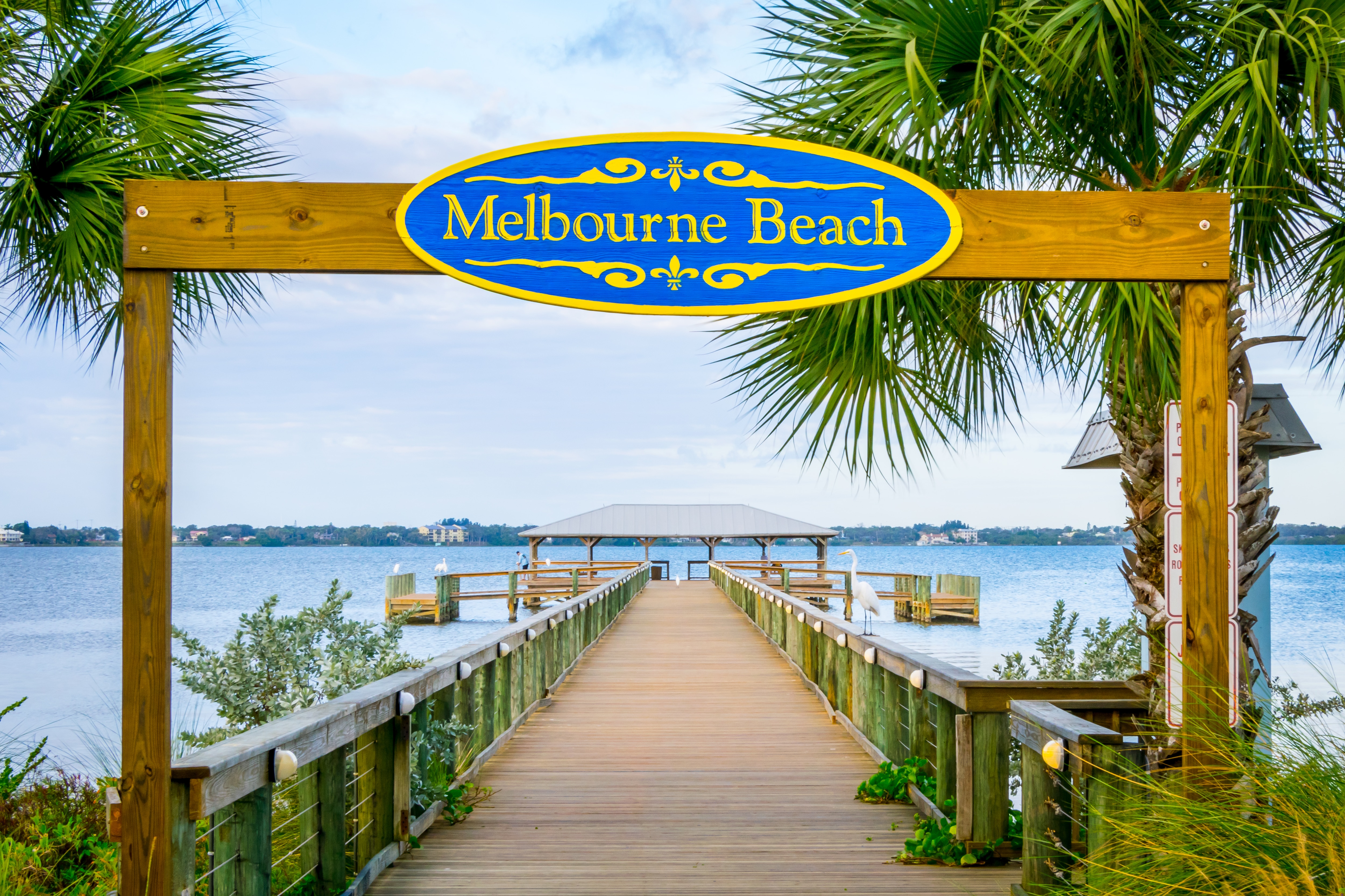 Melbourne Beach sign and pier in Melbourne Beach, Florida.