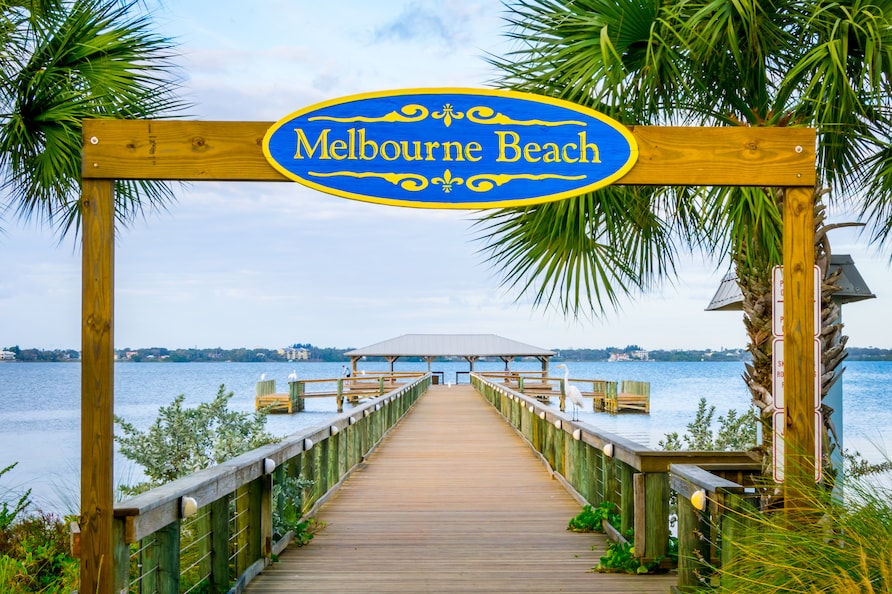 Melbourne Beach sign and pier in Melbourne Beach, Florida.