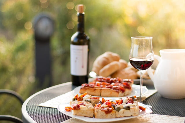 Wine and flat bread on a table outdoors.
