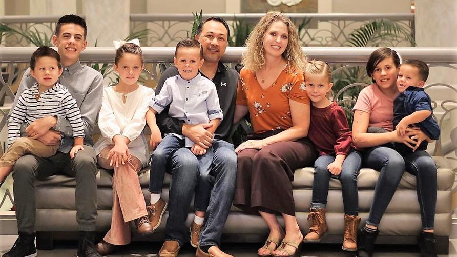 Family vacation photo at Elara, a Hilton Grand Vacations Club in Las Vegas after couple adopts seven siblings in foster care. 