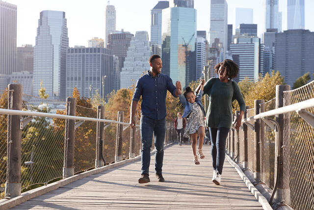 Family of three joyfully walking across an the High Line in New York City.