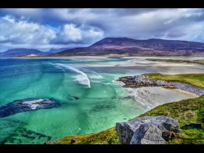 Aerial view of emerald seas and lush green cliffs at Luskentyre Beach Isle of Harris, Scotland.