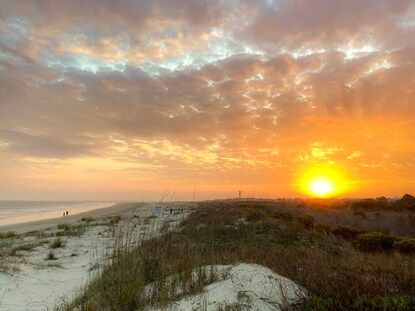 Sunset over sand dunes at Sullivan's Island Beach Charleston, South Carolina.