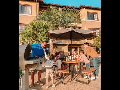 Multigenerational family enjoying the grills at Hilton Grand Vacations at MarBrisa in Carlsbad, California. 