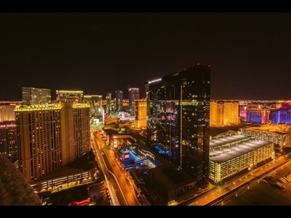 Nighttime aerial shot of Elara, a Hilton Grand Vacations Club and the Las Vegas Strip lit up. 