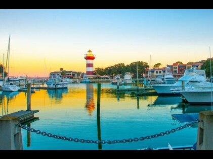 Boat Marina at with light house in the distance at sunset on Hilton Head island, South Carolina.