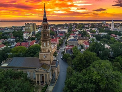 Aerial view of church steeple against sunset painted skies in Charleston, South Carolina. 