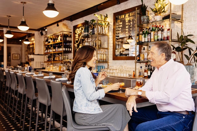 Couple sitting at a bar enjoying each other's company while on a date. 