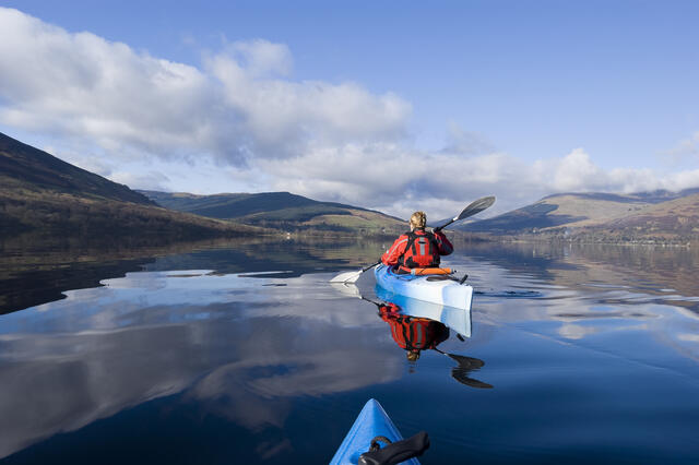 Travelers kayaking in Scotland on a summer vacation. 