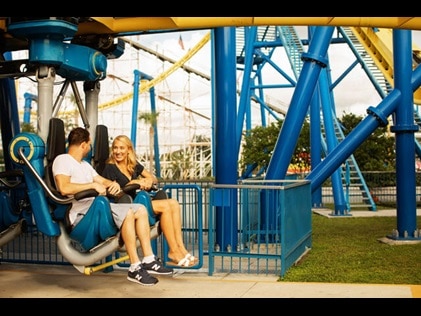 A couple on a roller coaster rides smiling at each other at a theme park in Orlando, Florida. 