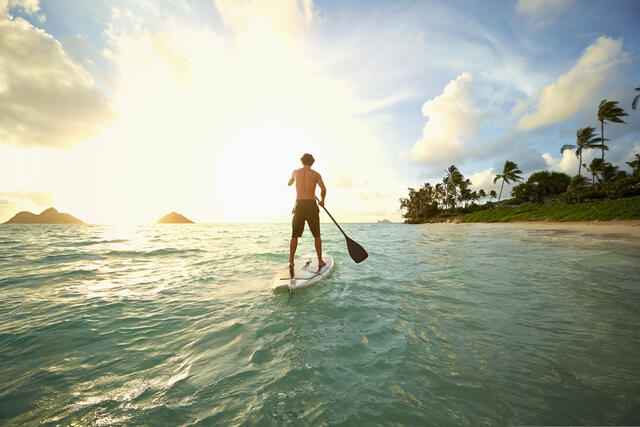 Man stand up paddle boarding while on vacation. 