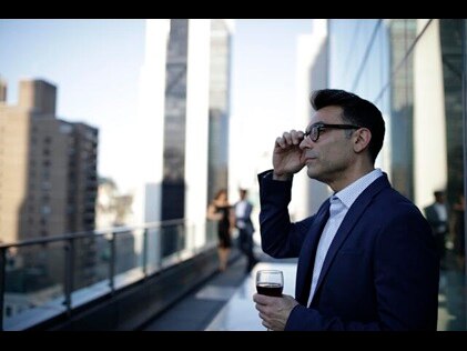 Man enjoying a beverage while taking in the New York City Skyline from the Owners Terrace at West 57th Street by Hilton Club, a New York City timeshare. 