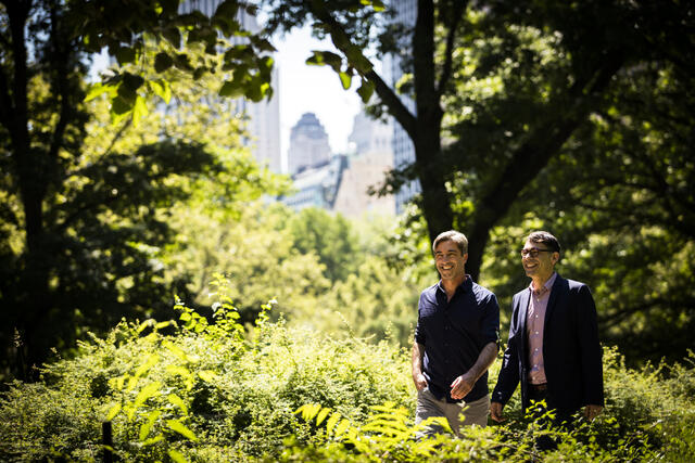 Two men smiling and walking in Central Park in New York City.