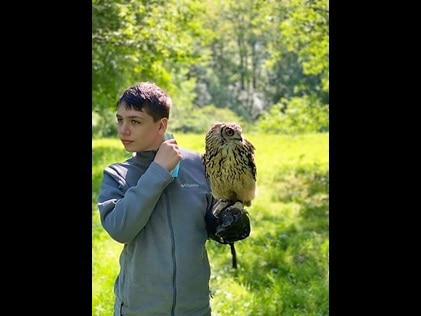 Teenage boy holding a bird of prey during Elite Falconry demonstration in Dunkeld, Scotland. 