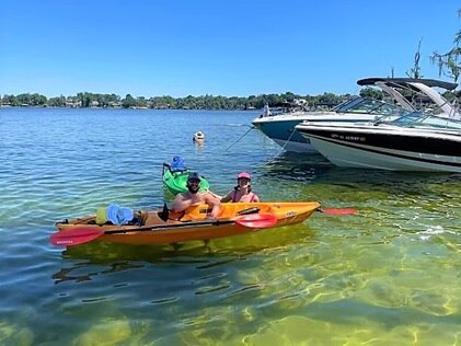 Hilton Grand Vacations Explorers posing with kayaks in Butler Chain of Lakes, Central Florida. 