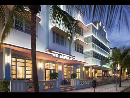 Exterior shot of Hilton Grand Vacations at McAlpin-Ocean Plaza lit up at nighttime in Miami, Florida. 