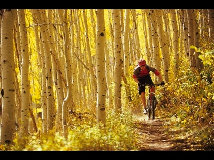 Man on an electric mountain bike on a fall foliage colored bike trail in Park City, Utah. 