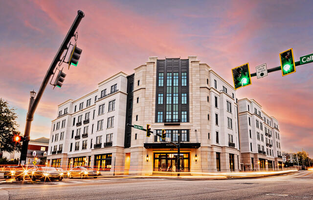 Exterior shot of Liberty Place Charleston by Hilton Club with pink painted skies overhead in South Carolina. 