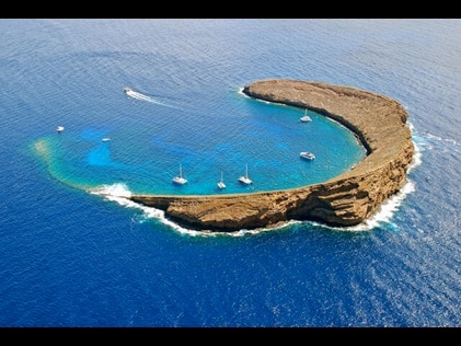 Aerial shot of Molokini with boats peppered throughout the turquois inlet, Maui, Hawaii.  