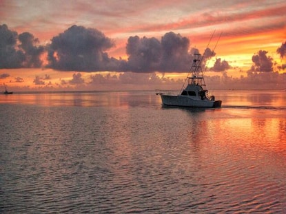 Silhouette of fishing boat on Charleston, South Carolina, waterway at sunset.