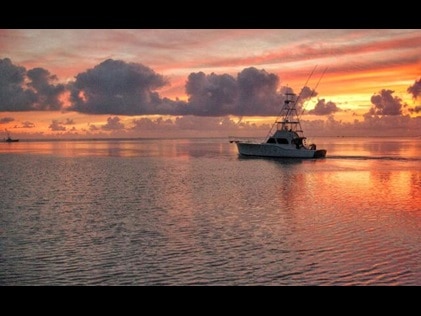 Silhouette of fishing boat on Charleston, South Carolina, waterway at sunset.