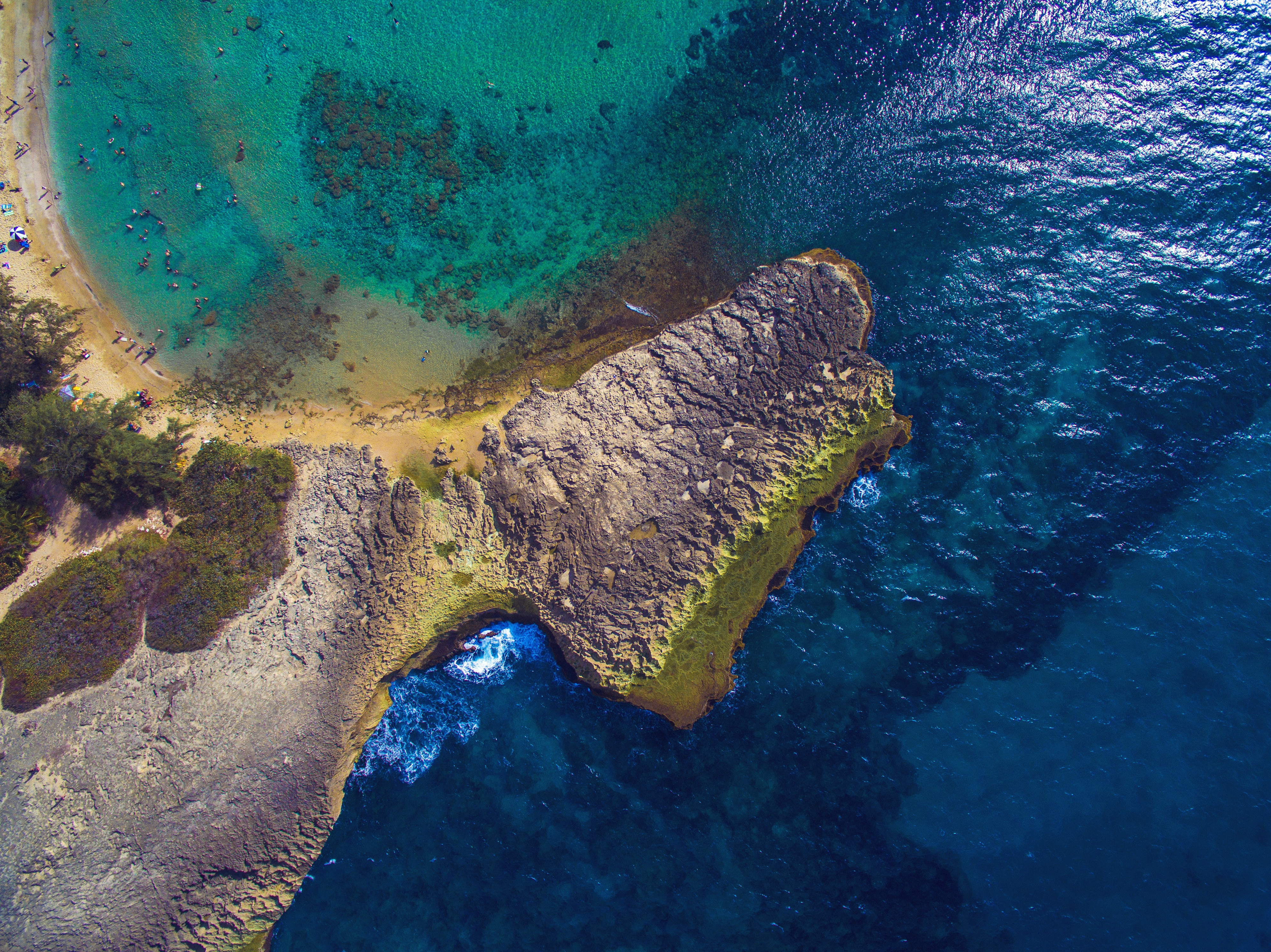 Aerial shot of a crescent shapped beach dotted with beachgoers in Puerto Rico.
