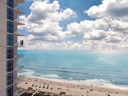 Aerial shot of Ocean Enclave by Hilton Grand Vacations with people admiring oceanviews from the balcony in Myrtle Beach, South Carolina. 