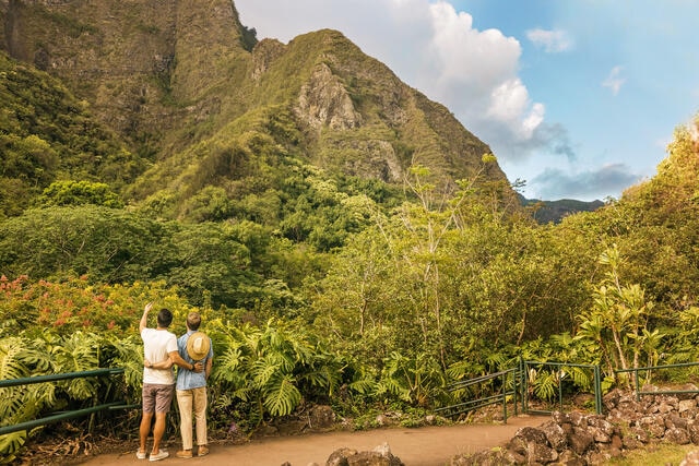 Couple cuddling while appreciating the natural beauty in the mountains in Hawaii.