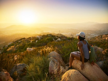 Woman hiker stopping to enjoy the sunrise view, Carlsbad, California. 