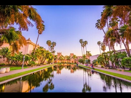 Spanish style architecture and palm trees against purple painted sunset skies, Carlsbad, California. 