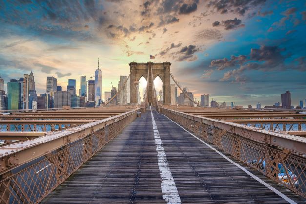 Point of view shot of Brooklyn Bridge with the sunrising over the city skyline, New York, New York. 