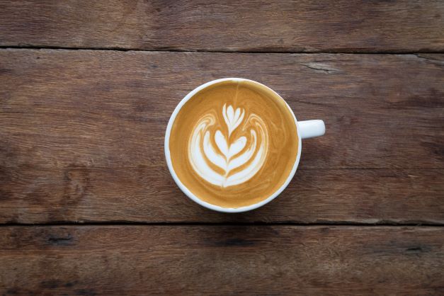 Overhead shot of a latte with a coffe art flower in the foam. 