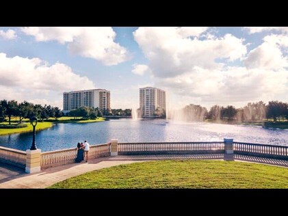 Family enjoying green spaces and lakeside views at Parc Soleil, a Hilton Grand Vacations Club, Orlando, Florida. 