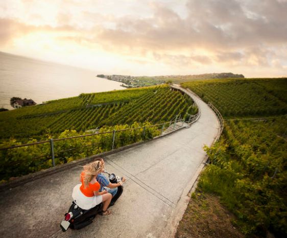 Couple riding on a vesa through the countryside, Tuscany, Italy.