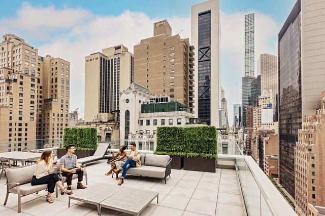 Four friends enjoying the rooftop terrace at The Quin, a Hilton Club, New York, New York. 