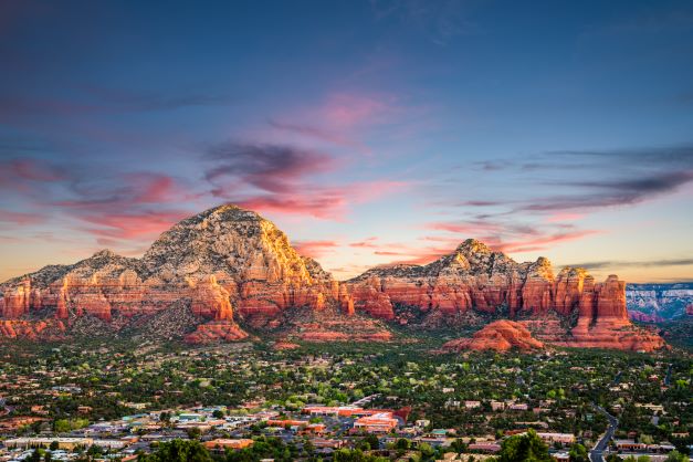 Stunning aerial shot of downtown Sedona, Airzona, with painted skies overhead bold red rocks.