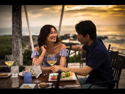 Couple dining alfresco at sunset at Kings' Land, a Hilton Grand Vacations Club, Big Island, Hawaii. 
