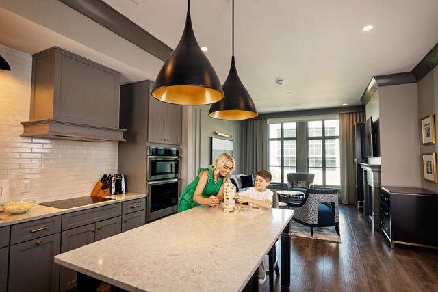 Woman and young boy playing board game in stunning kitchen, Liberty Place, a Hilton Club, Charleston, South Carolina.