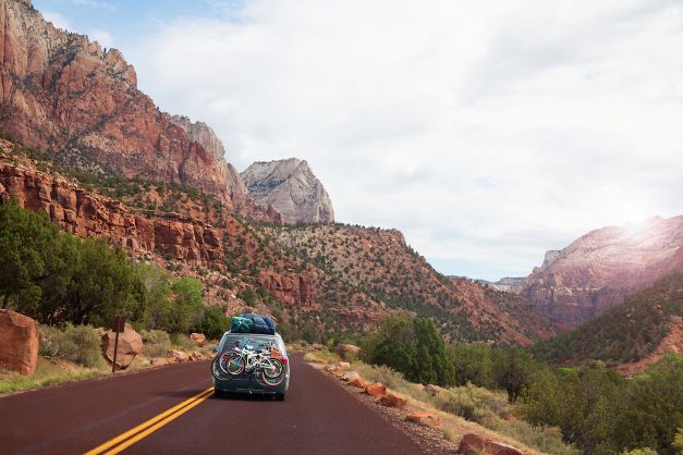 A car with bikes on the road through Southern Utah
