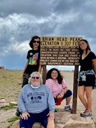Hilton Grand Vacations Owner and his family at a sign marking Brian Head Peak